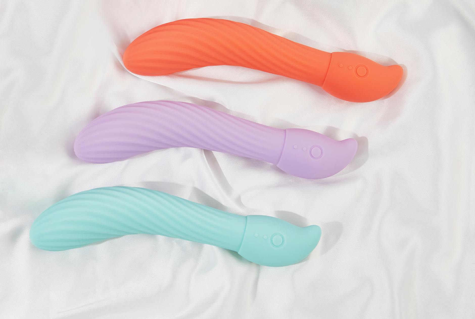 Vibromasseur élégant sur du tissu blanc et lisse